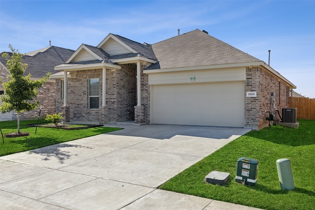 ranch-style home featuring a front lawn, a garage, and central AC unit