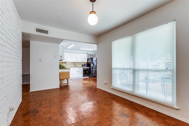 interior space with parquet floors and brick wall