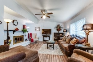 living room with lofted ceiling, ceiling fan, and hardwood / wood-style flooring