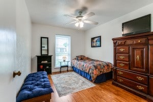 bedroom with wood-type flooring and ceiling fan