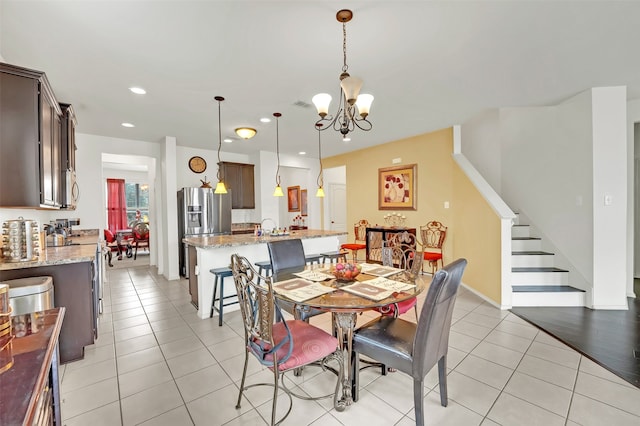 dining area with light wood-type flooring and an inviting chandelier