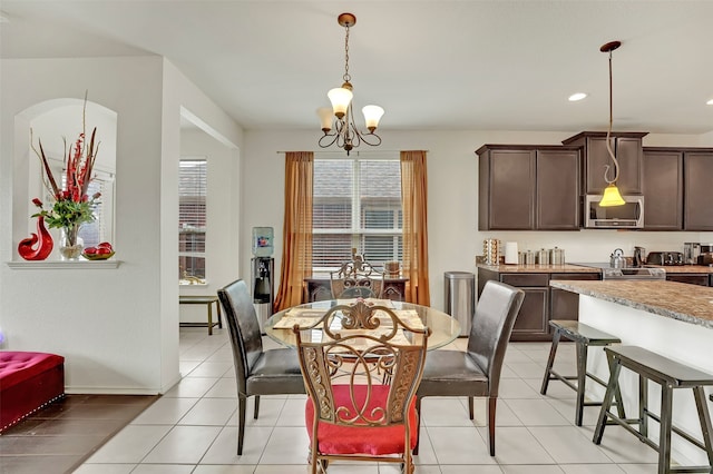 dining space featuring an inviting chandelier and light tile patterned flooring