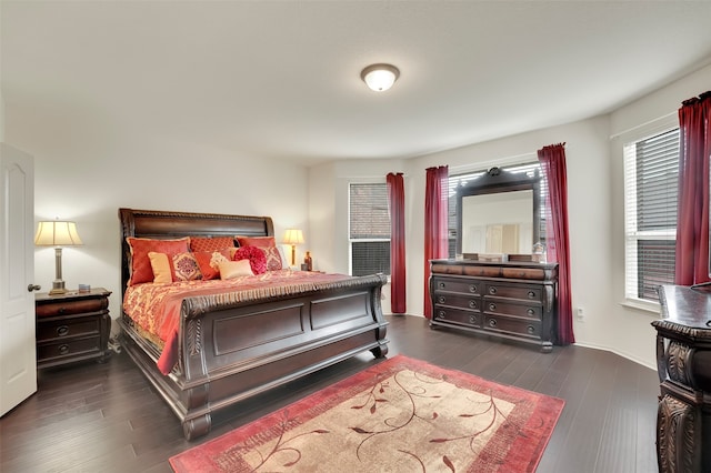 bedroom with dark wood-type flooring and multiple windows