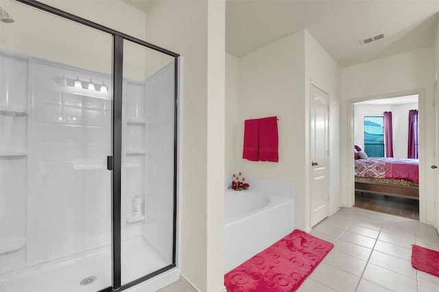 bathroom featuring tile patterned flooring and separate shower and tub