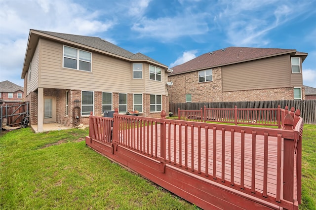 back of property featuring a yard and a wooden deck