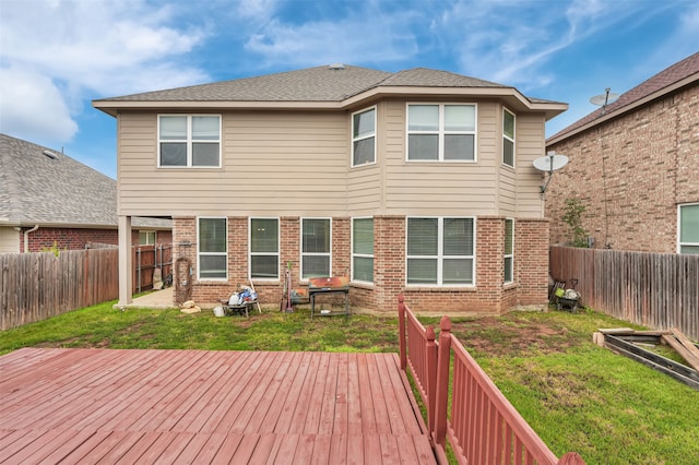 rear view of house with a wooden deck and a yard