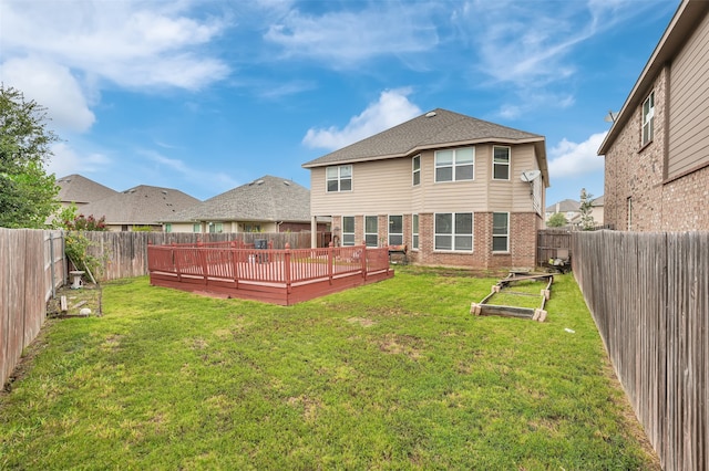 rear view of property featuring a yard and a wooden deck