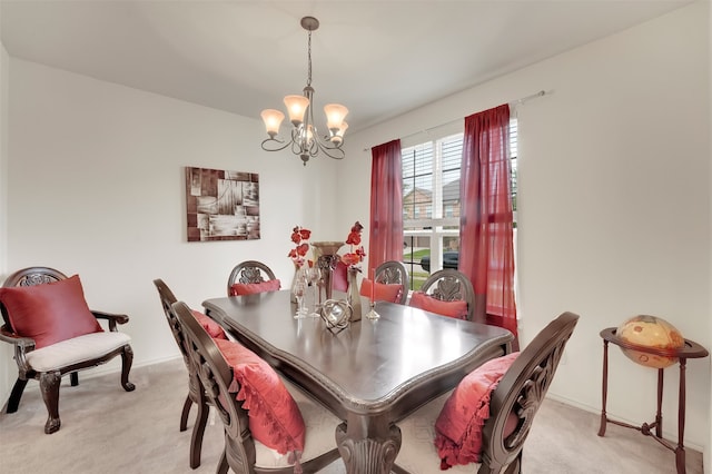 dining area with light carpet and a chandelier