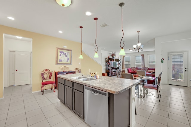 kitchen with a center island with sink, stainless steel dishwasher, hanging light fixtures, sink, and a chandelier