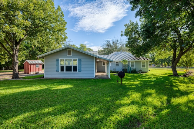 back of house featuring a yard and a storage shed