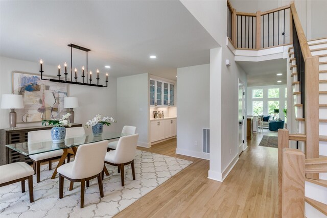 dining space with a notable chandelier and light hardwood / wood-style flooring