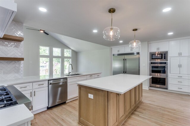 kitchen with light wood-type flooring, built in appliances, tasteful backsplash, a kitchen island, and sink