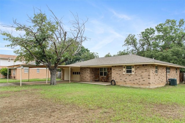 rear view of property with a yard, a carport, and central AC