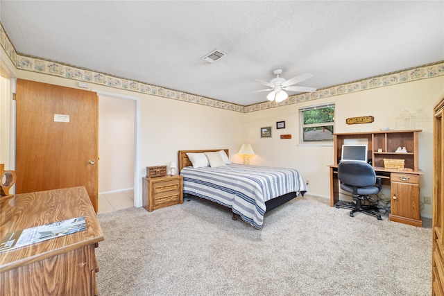 carpeted bedroom featuring a textured ceiling and ceiling fan