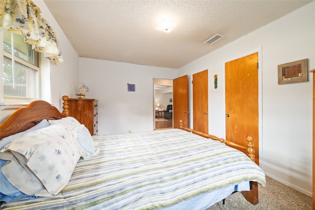 carpeted bedroom with a textured ceiling