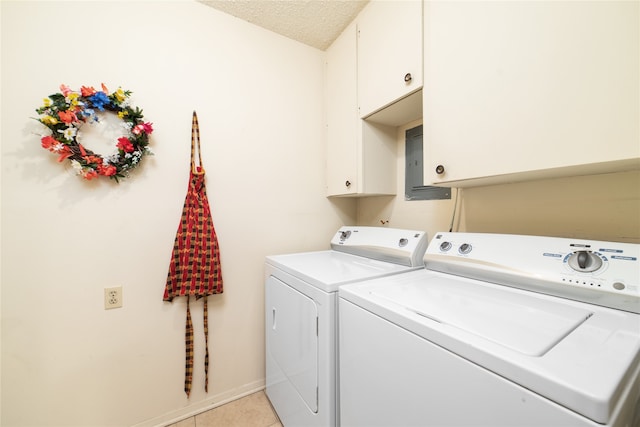 laundry area featuring light tile patterned floors, washing machine and clothes dryer, cabinets, and a textured ceiling