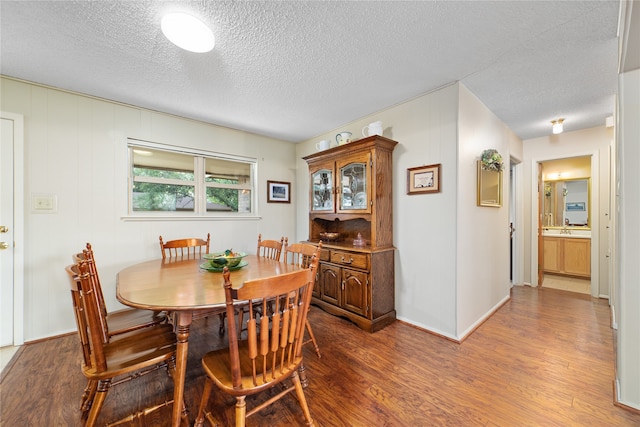 dining room featuring a textured ceiling and hardwood / wood-style floors