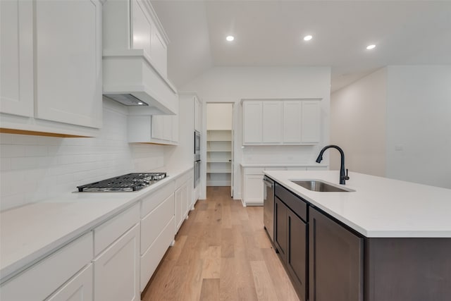 kitchen with white cabinets, light wood-type flooring, stainless steel appliances, and sink