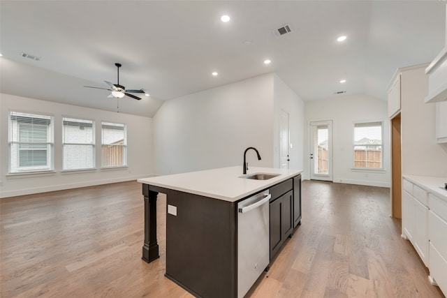 kitchen featuring lofted ceiling, sink, stainless steel dishwasher, white cabinetry, and light wood-type flooring