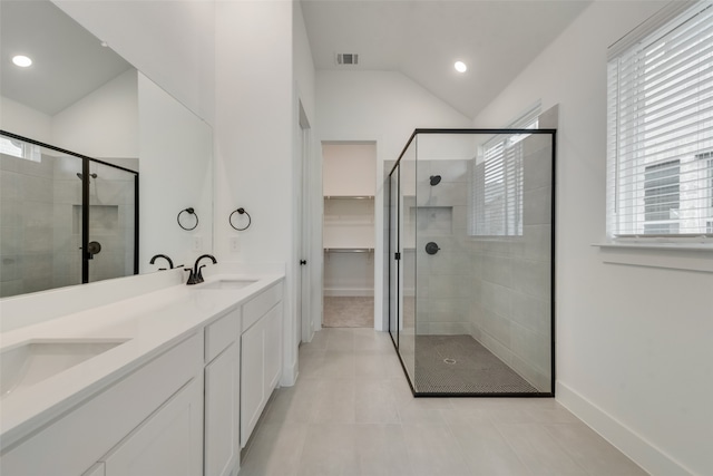 bathroom featuring an enclosed shower, vanity, tile patterned floors, and vaulted ceiling