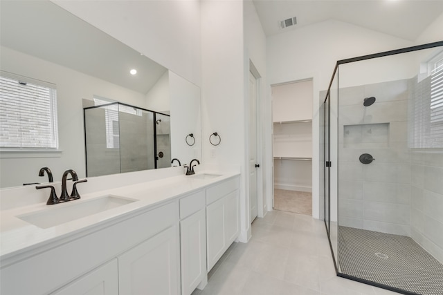 bathroom featuring a shower with door, lofted ceiling, tile patterned floors, and vanity