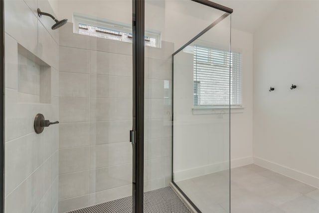 bathroom with an enclosed shower, a wealth of natural light, and tile patterned flooring