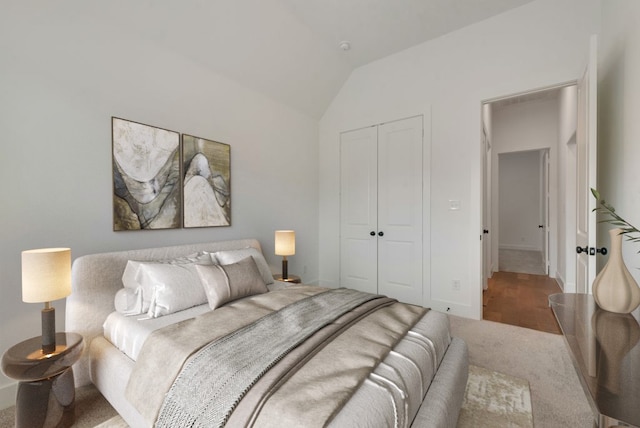 carpeted bedroom with a closet and lofted ceiling