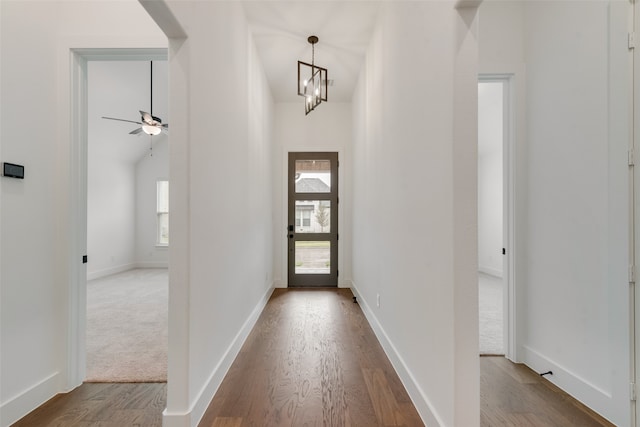 foyer featuring light hardwood / wood-style floors and ceiling fan with notable chandelier