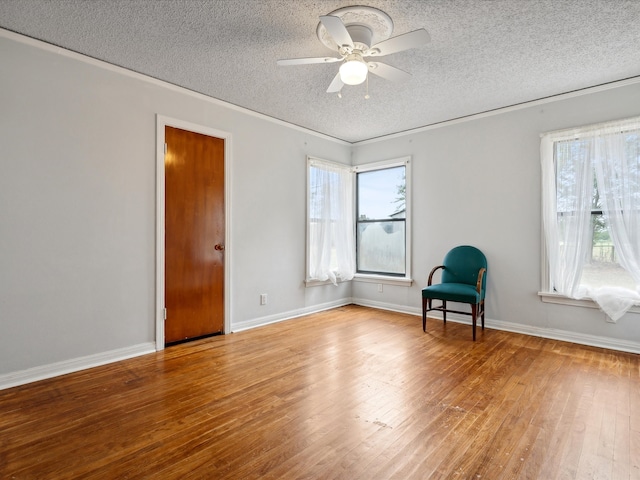 unfurnished room featuring hardwood / wood-style floors, ceiling fan, and a textured ceiling