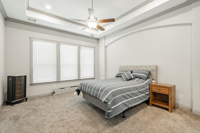 carpeted bedroom with multiple windows, ceiling fan, a tray ceiling, and ornamental molding