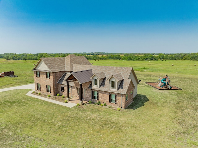 view of front of home with a rural view and a front lawn