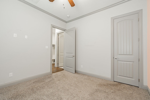 unfurnished bedroom featuring ceiling fan, ornamental molding, and light carpet