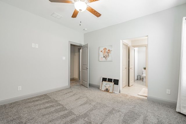 unfurnished bedroom featuring ceiling fan, light carpet, and connected bathroom