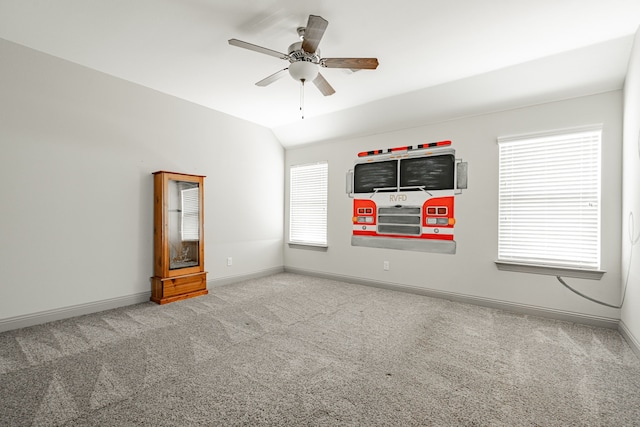 carpeted empty room featuring lofted ceiling, a wealth of natural light, and ceiling fan