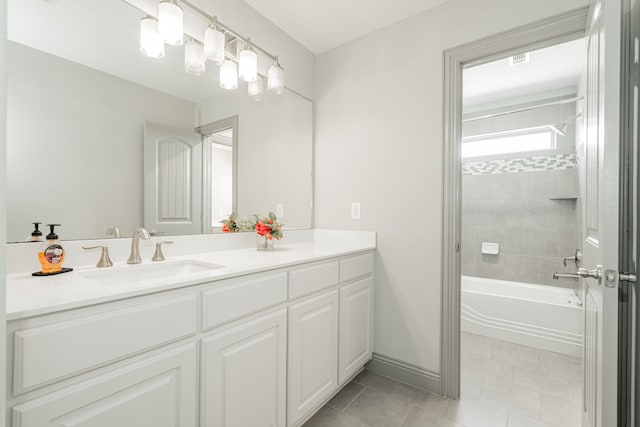 bathroom featuring tiled shower / bath combo, vanity, and tile patterned floors