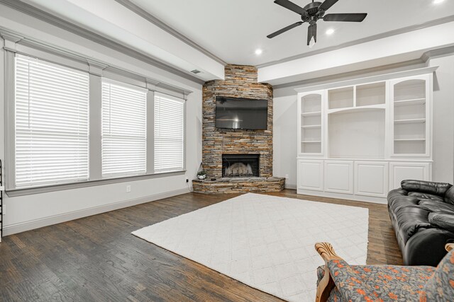 living room featuring ceiling fan, a fireplace, dark hardwood / wood-style flooring, and ornamental molding