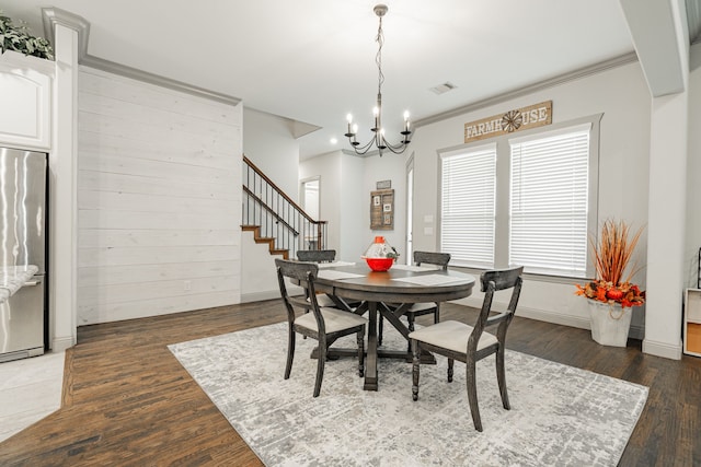 dining area with crown molding, hardwood / wood-style floors, and a notable chandelier