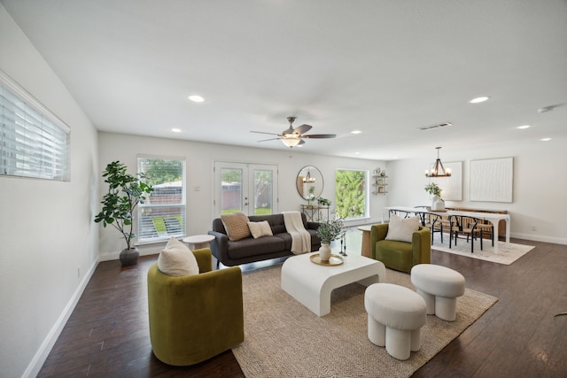 living room featuring ceiling fan with notable chandelier, dark hardwood / wood-style flooring, and french doors