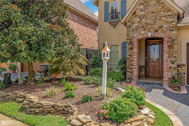 view of exterior entry featuring stucco siding and stone siding