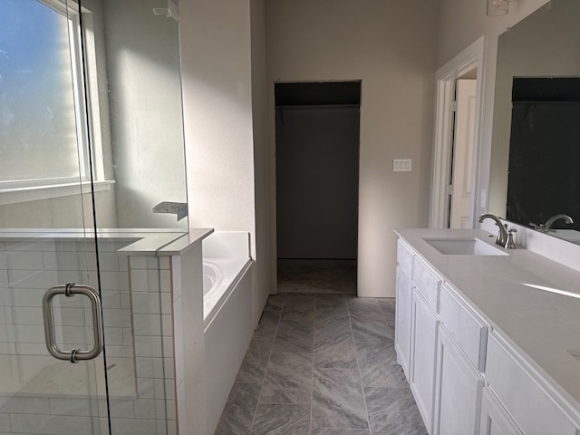 bathroom featuring plus walk in shower, vanity, and tile patterned flooring