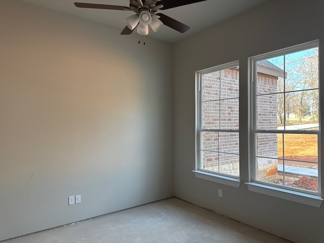 empty room with ceiling fan and concrete flooring