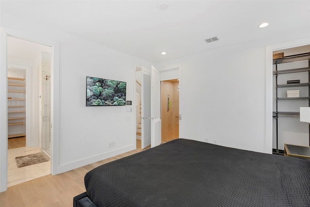 bedroom with connected bathroom, a closet, and light hardwood / wood-style floors