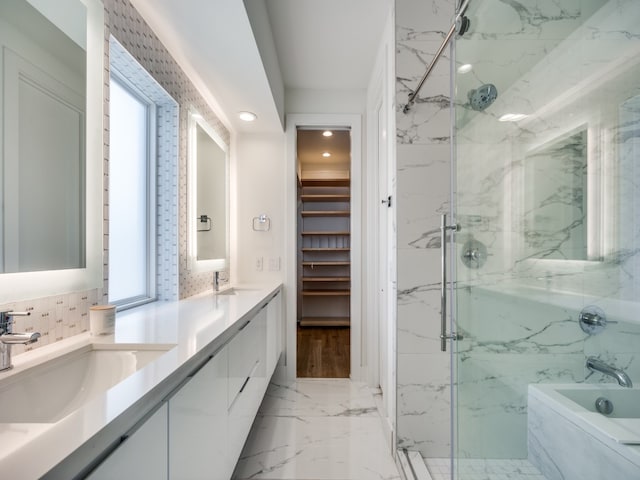 bathroom featuring a healthy amount of sunlight, independent shower and bath, and vanity