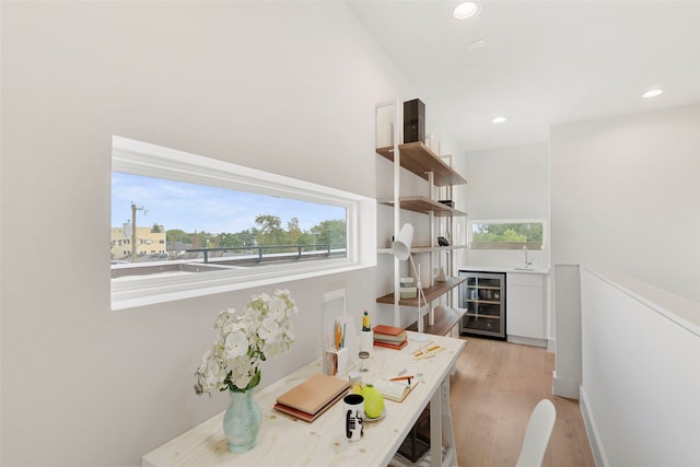 interior space with wine cooler, sink, and light hardwood / wood-style floors