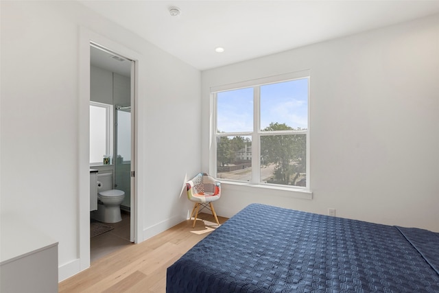 bedroom featuring ensuite bath and light hardwood / wood-style flooring