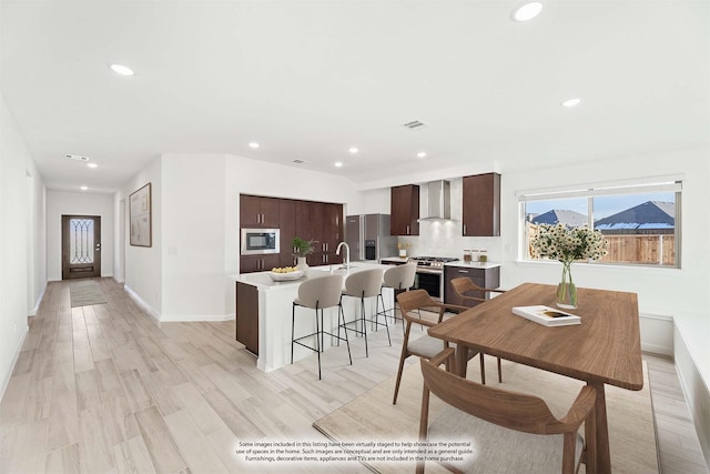 dining space with sink and light hardwood / wood-style flooring