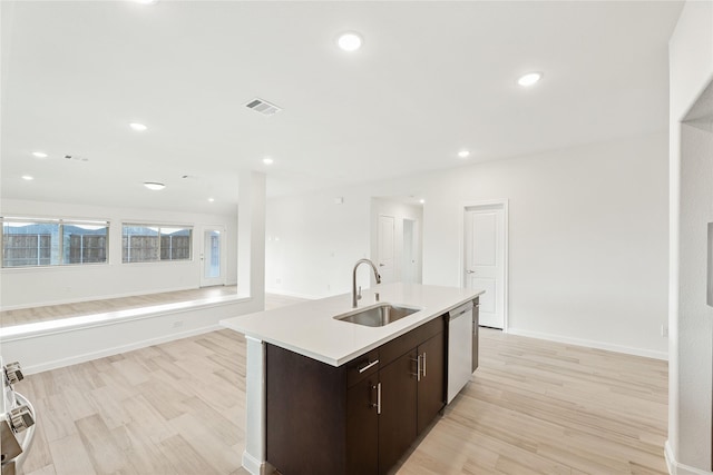 kitchen with sink, dishwasher, dark brown cabinetry, a center island with sink, and light wood-type flooring