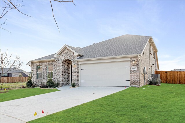 ranch-style house featuring a garage and a front lawn