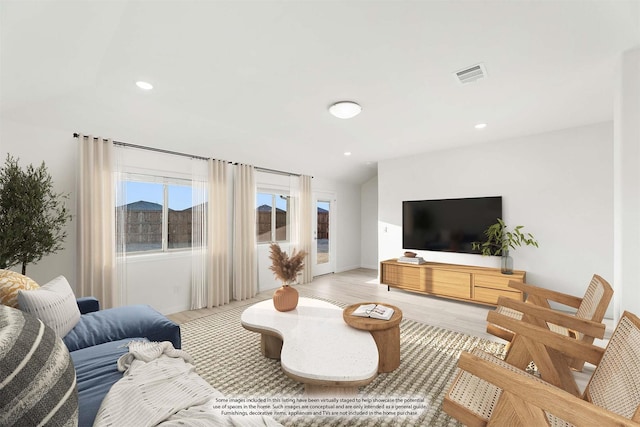 living room with vaulted ceiling and light hardwood / wood-style floors