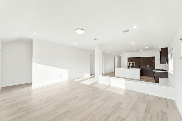 unfurnished living room featuring lofted ceiling and light hardwood / wood-style floors